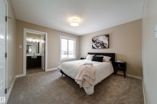 Carpeted bedroom with a textured ceiling and ensuite bathroom - 2919 15 Street, Edmonton, AB - Indoor Photo Showing Bedroom