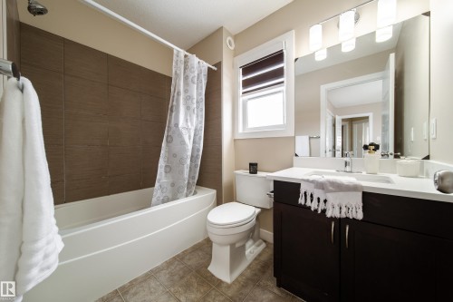 Bathroom with vanity, shower / tub combo, and light tile patterned flooring - 2919 15 Street, Edmonton, AB - Indoor Photo Showing Bathroom