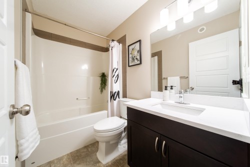 Bathroom with vanity, shower / bathtub combination with curtain, and light tile patterned floors - 2919 15 Street, Edmonton, AB - Indoor Photo Showing Bathroom