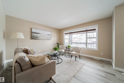 Living area with light wood finished floors and a textured ceiling - 2919 15 Street, Edmonton, AB - Indoor Photo Showing Living Room