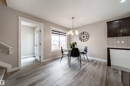 Dining room featuring a textured ceiling, light wood-style floors, and hanging lights - 2919 15 Street, Edmonton, AB - Indoor Photo Showing Dining Room