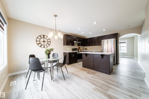 Dining area featuring arched walkways, light wood finished floors, and hanging lights - 2919 15 Street, Edmonton, AB - Indoor