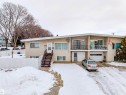 View of front of home featuring stucco siding, a garage, and a balcony - 7918 121 Avenue, Edmonton, AB  - Outdoor With Facade 
