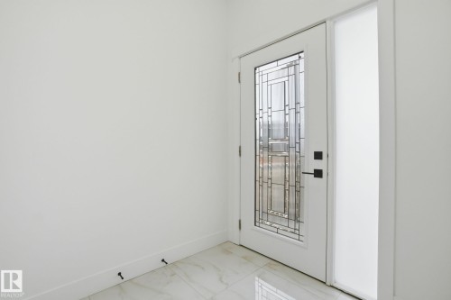 Doorway with baseboards and marble look tiles - 3294 Chernowski Way, Edmonton, AB - Indoor Photo Showing Other Room