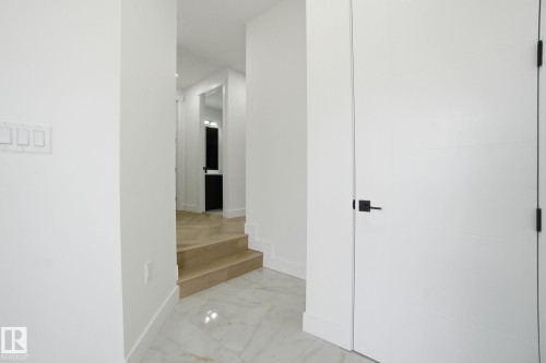 Corridor with baseboards and light marble finish floors - 3294 Chernowski Way, Edmonton, AB - Indoor Photo Showing Other Room
