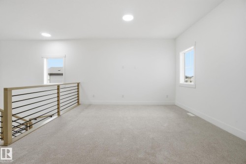Empty room featuring light colored carpet, plenty of natural light, and recessed lighting - 3294 Chernowski Way, Edmonton, AB - Indoor