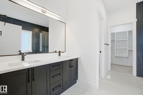 Full bathroom with a spacious closet, double vanity, light marble finish flooring, and a stall shower - 3294 Chernowski Way, Edmonton, AB - Indoor Photo Showing Bathroom