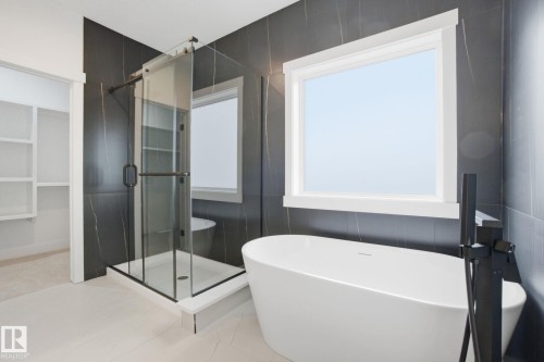 Bathroom featuring a stall shower and a freestanding bath - 3294 Chernowski Way, Edmonton, AB - Indoor Photo Showing Bathroom