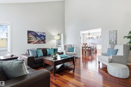 Living room with hardwood / wood-style floors, hanging lights, plenty of natural light, and a high ceiling - 326 O'Connor Close, Edmonton, AB - Indoor Photo Showing Living Room