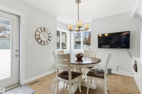 Dining room featuring light tile patterned floors, a textured ceiling, and hanging lights - 326 O'Connor Close, Edmonton, AB - Indoor Photo Showing Dining Room