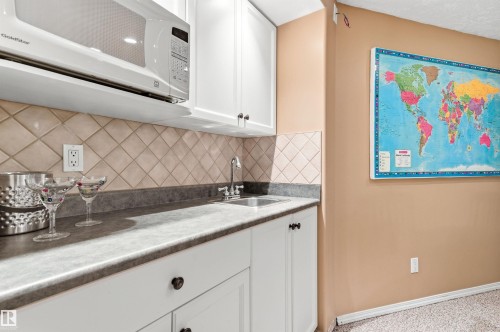 Kitchen featuring white microwave, white cabinets, and tasteful backsplash - 326 O'Connor Close, Edmonton, AB - Indoor Photo Showing Kitchen