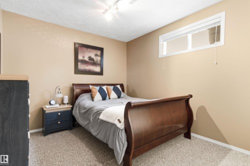 Bedroom with rail lighting, light carpet, and a textured ceiling - 326 O'Connor Close, Edmonton, AB - Indoor Photo Showing Bedroom