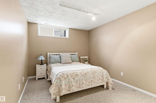 Bedroom featuring a textured ceiling, light carpet, and rail lighting - 326 O'Connor Close, Edmonton, AB - Indoor Photo Showing Bedroom