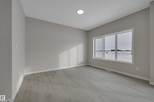 Unfurnished room with baseboards and light wood-style flooring - 5657 Hawthorn Way, Edmonton, AB - Indoor Photo Showing Other Room