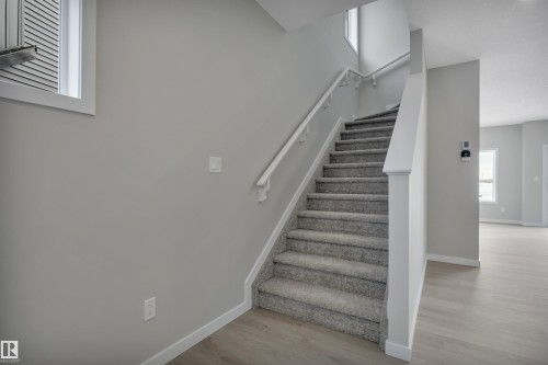 Stairs with baseboards and wood finished floors - 5657 Hawthorn Way, Edmonton, AB - Indoor Photo Showing Other Room