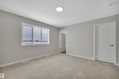 Unfurnished bedroom featuring baseboards and light colored carpet - 5657 Hawthorn Way, Edmonton, AB - Indoor Photo Showing Other Room
