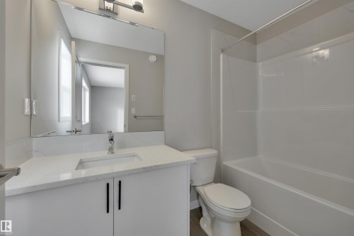 Bathroom featuring vanity,  shower combination, and wood finished floors - 5657 Hawthorn Way, Edmonton, AB - Indoor Photo Showing Bathroom