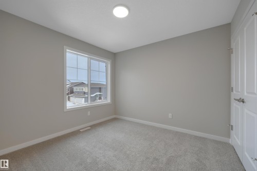 Unfurnished room featuring baseboards and light carpet - 5657 Hawthorn Way, Edmonton, AB - Indoor Photo Showing Other Room