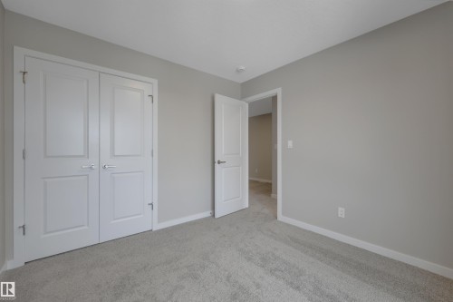 Unfurnished bedroom featuring light carpet and a closet - 5657 Hawthorn Way, Edmonton, AB - Indoor Photo Showing Other Room