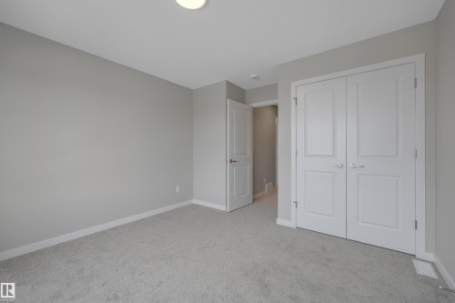 Unfurnished bedroom featuring light colored carpet and a closet - 5657 Hawthorn Way, Edmonton, AB - Indoor Photo Showing Other Room