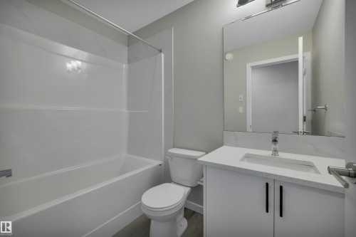 Bathroom featuring vanity, shower / tub combination, and dark wood-style floors - 5657 Hawthorn Way, Edmonton, AB - Indoor Photo Showing Bathroom