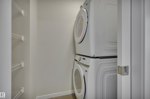 Laundry room with baseboards and stacked washer and clothes dryer - 5657 Hawthorn Way, Edmonton, AB - Indoor Photo Showing Laundry Room