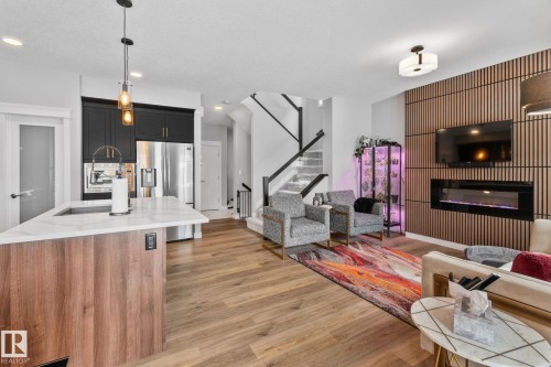 Living room with light wood finished floors, a glass covered fireplace, and recessed lighting - 324 41 Street, Edmonton, AB - Indoor With Fireplace
