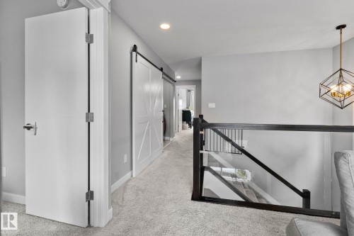 Corridor featuring light colored carpet, an upstairs landing, a barn door, and recessed lighting - 324 41 Street, Edmonton, AB - Indoor Photo Showing Other Room