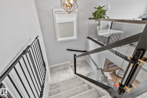Stairs featuring baseboards and a chandelier - 324 41 Street, Edmonton, AB - Indoor Photo Showing Other Room