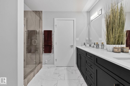 Bathroom featuring double vanity, a marble finish shower, light marble finish floors, and a textured ceiling - 324 41 Street, Edmonton, AB - Indoor Photo Showing Bathroom