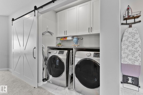 Laundry area with a barn door, cabinet space, and washing machine and dryer - 324 41 Street, Edmonton, AB - Indoor Photo Showing Laundry Room