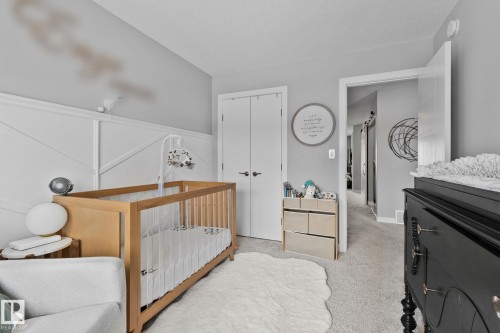 Bedroom featuring light colored carpet, a crib, and a closet - 324 41 Street, Edmonton, AB - Indoor Photo Showing Bedroom