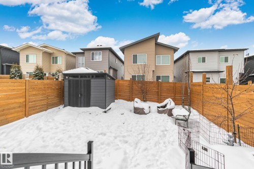 Yard covered in snow with a residential view, a fenced backyard, and a storage shed - 324 41 Street, Edmonton, AB - Outdoor