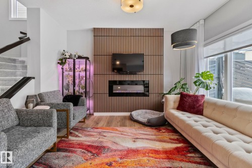 Living area with light wood-style flooring and a glass covered fireplace - 324 41 Street, Edmonton, AB - Indoor Photo Showing Living Room With Fireplace