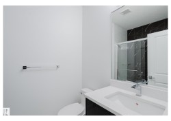 Bathroom featuring vanity and a marble finish shower - 
