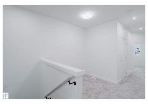 Corridor featuring light colored carpet, an upstairs landing, and recessed lighting - 231 25 Street Sw, Edmonton, AB - Indoor Photo Showing Other Room