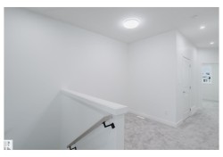 Corridor featuring light colored carpet, an upstairs landing, and recessed lighting - 