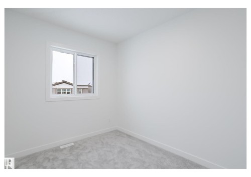 Empty room featuring baseboards and light carpet - 231 25 Street Sw, Edmonton, AB - Indoor Photo Showing Other Room