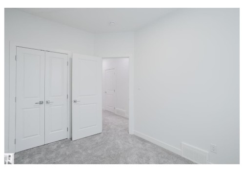 Unfurnished bedroom with light carpet and a closet - 231 25 Street Sw, Edmonton, AB - Indoor Photo Showing Other Room