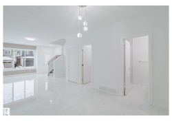 Unfurnished dining area featuring stairway and light marble finish floors - 