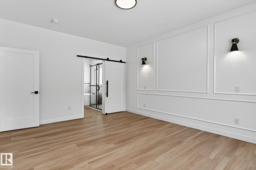 Unfurnished room with a barn door and light wood-type flooring - 3318 Chickadee Drive, Edmonton, AB - Indoor Photo Showing Other Room