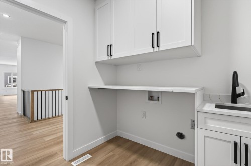 Laundry area featuring cabinet space, light wood-style floors, washer hookup, and recessed lighting - 3318 Chickadee Drive, Edmonton, AB - Indoor