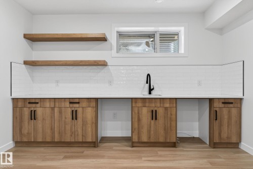 Bar with wood finish cabinets, backsplash, open shelves, and light wood finished floors - 3318 Chickadee Drive, Edmonton, AB - Indoor Photo Showing Other Room