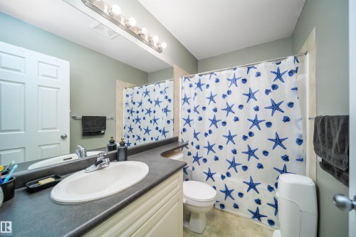 Bathroom with vanity and shower / tub combo with curtain - 1179 Oakland Drive, Devon, AB - Indoor Photo Showing Bathroom