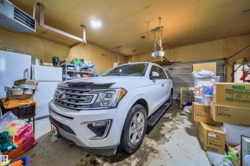 Garage with a heating unit and freestanding refrigerator - 1179 Oakland Drive, Devon, AB - Indoor Photo Showing Garage