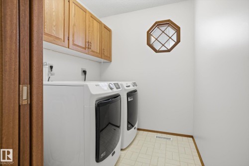 Laundry room featuring independent washer and dryer, cabinet space, and a textured ceiling - 65 Lorne Crescent, St. Albert, AB - Indoor Photo Showing Laundry Room