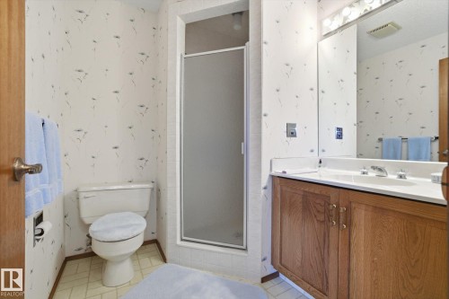Bathroom featuring wallpapered walls, vanity, a stall shower, and light flooring - 65 Lorne Crescent, St. Albert, AB - Indoor Photo Showing Bathroom