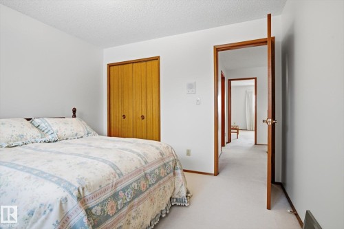 Bedroom with light colored carpet, a textured ceiling, and a closet - 65 Lorne Crescent, St. Albert, AB - Indoor Photo Showing Bedroom