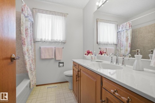 Full bathroom with vanity, a textured ceiling, and shower / bath combination with curtain - 65 Lorne Crescent, St. Albert, AB - Indoor Photo Showing Bathroom