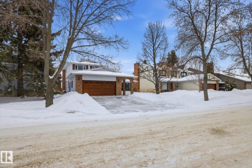 View of front of property with a chimney, brick siding, and an attached garage - 65 Lorne Crescent, St. Albert, AB - Outdoor